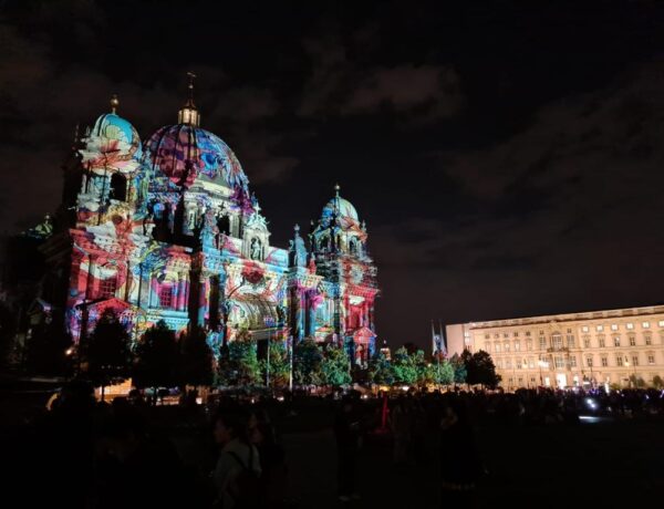 Berlim em Outubro: Catedral de Berlim iluminada com projeções coloridas durante o Festival de Luzes à noite.